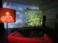 Beeld van de snoezelbioscoop: een donkere ruimte met verschillende kleuren licht op een doek