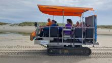 Afbeelding van mensen op een Strandrups (voertuig waarmee over het strand te rijden is)